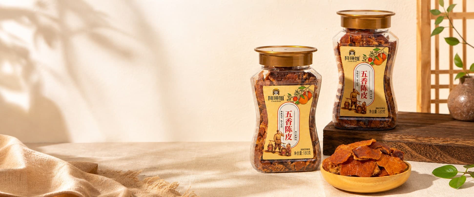 Jars of A SHAN SISTER preserved tangerine peel on a warm cream backdrop